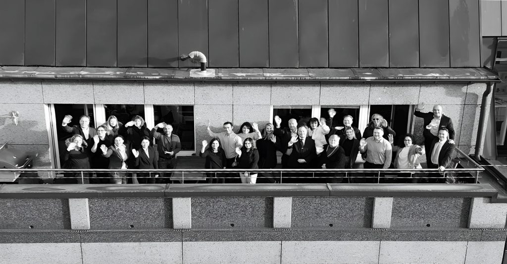 Bild von allen TA-LENT Mitarbeitern auf dem Balkon des Büros